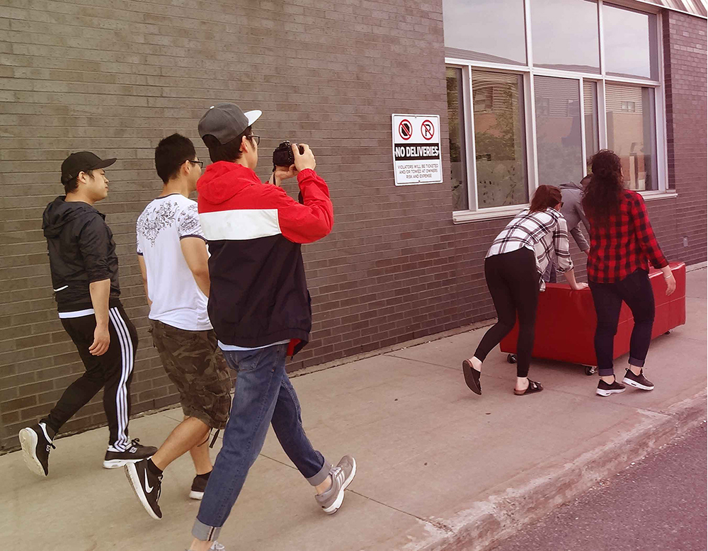 picture of the slide team moving the couch to the lab
