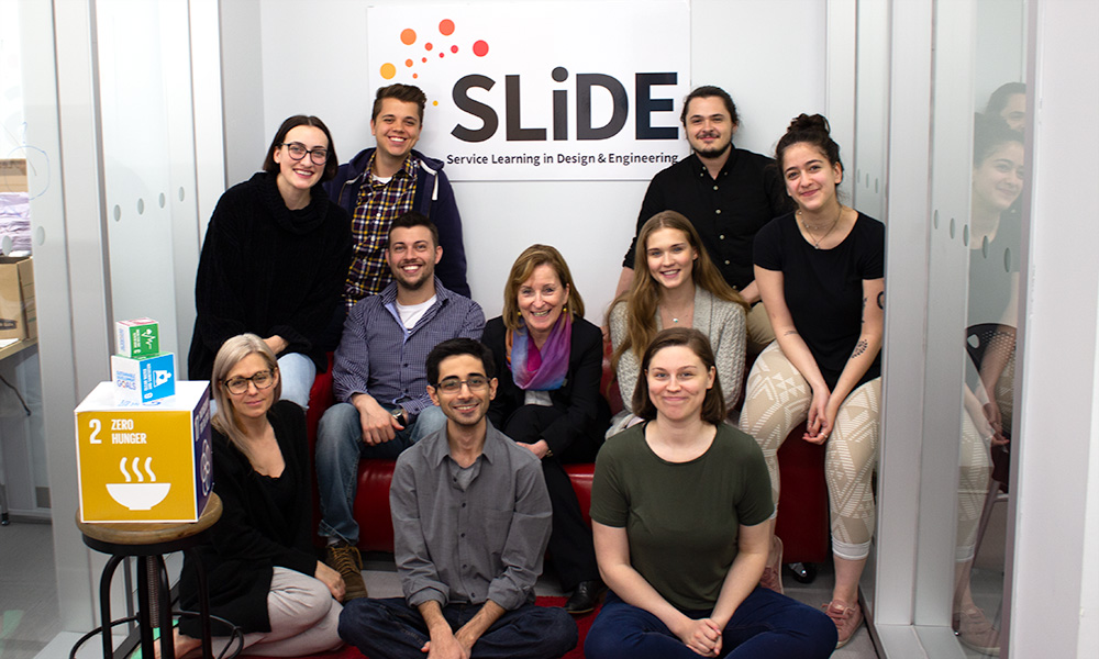 picture of the slide team members with college president Cheryl